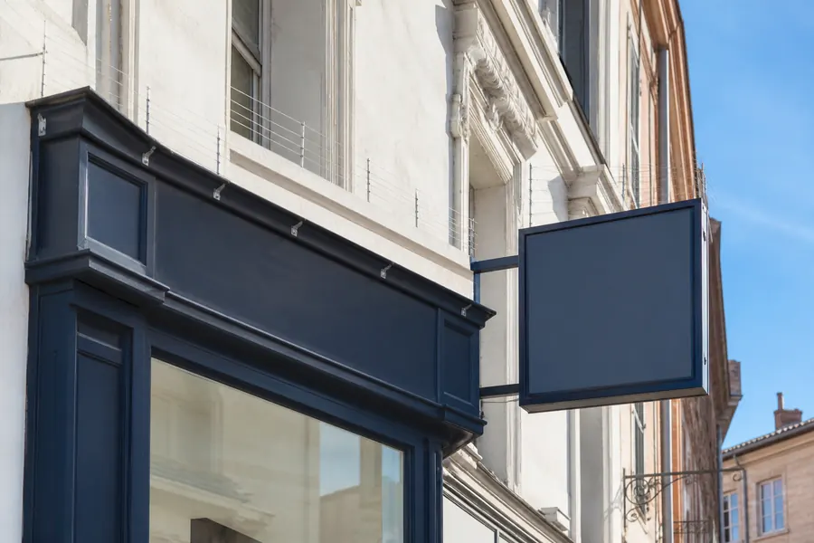 Enseigne commerciale protégée par un dispositif anti-pigeons discret